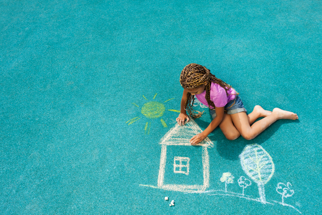 bilde av jente som tegner et hus med kritt