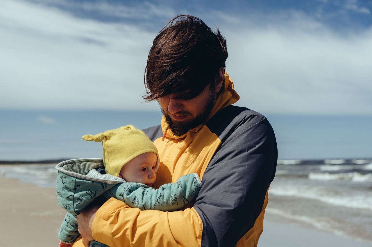 Fotografi av en far med sin baby på stranden