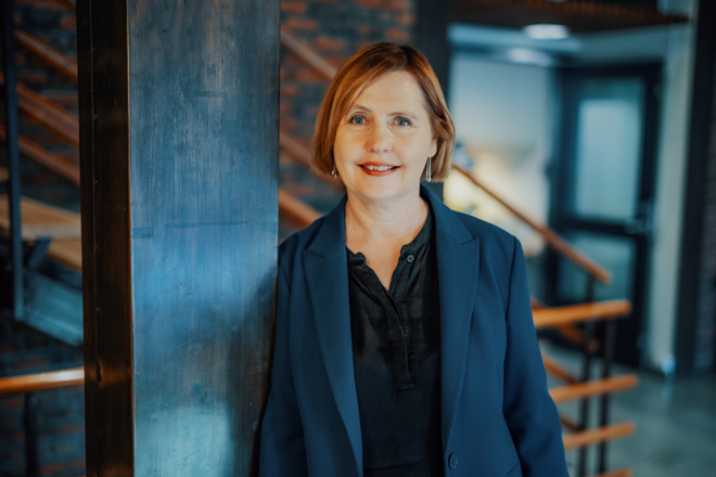 Bildet kan inneholde: smil, stående, ansiktsuttrykk, formelt antrekk, blazer.